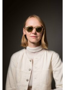 Femme portant la monture géométrique Kronos White Circle by Massada en titane japonais chez The House of Eyewear Paris